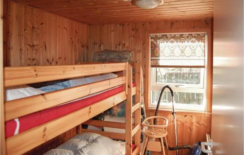 a bedroom with two bunk beds and a window at 3 Bedroom Stunning Home In Pandrup in Rødhus