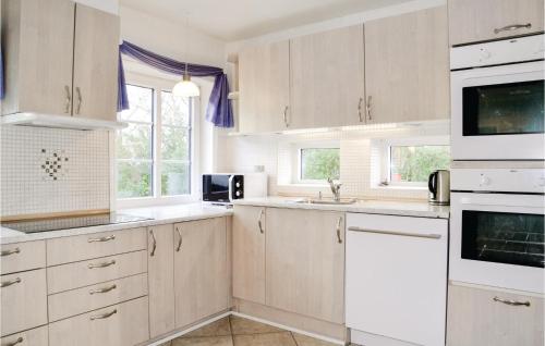 a kitchen with white cabinets and white appliances at Gorgeous Home In Bramming With Sauna in Bramming