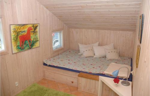 a bedroom with a bed in a wooden house at Cozy Home In Vggerlse With Wifi in Bøtø By