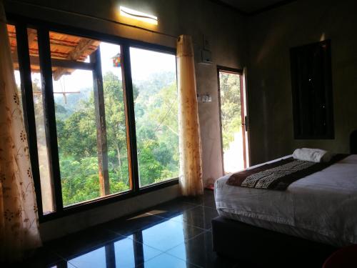 a bedroom with a bed and a large window at Nature Fruit Farm - Private Estate in Balik Pulau