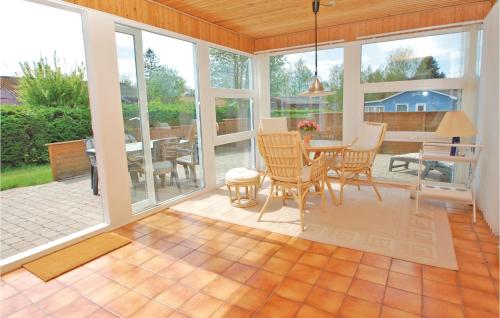 a screened in porch with a table and chairs at Mindegården in Hejls