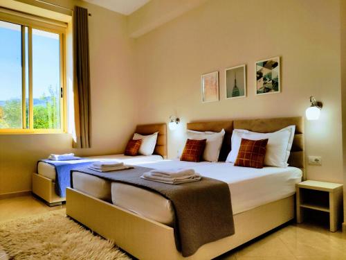 a bedroom with two beds and a large window at Olive B&B in Berat