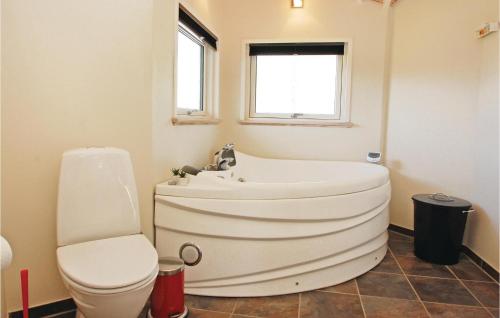 La salle de bains est pourvue d'une baignoire, de toilettes et d'un lavabo. dans l'établissement Beautiful Home In Aabenraa With Kitchen, à Loddenhøj