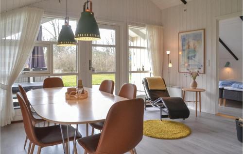 a dining room with a table and chairs and a bedroom at Holiday Home Møllevangen Ix in Ovtrup
