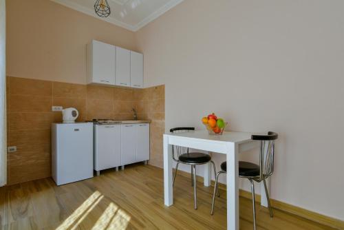 a kitchen with a white table and stools at Apartments Hillside in Ulcinj
