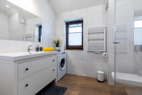 a white bathroom with a washing machine in it at Amare Apartments A2 in Mosty