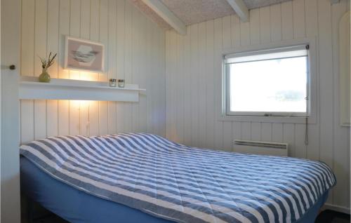 a bedroom with a blue bed with a window at Gorgeous Home In Ringkbing With Kitchen in Ringkøbing