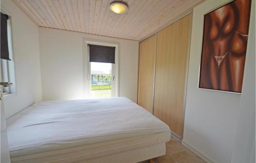 a bedroom with a bed and a window at 2 Bedroom Awesome Home In Struer in Humlum