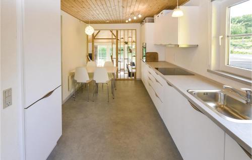 eine Küche mit weißen Schränken und ein Esszimmer in der Unterkunft Awesome Home In Broager With Wifi in Broager