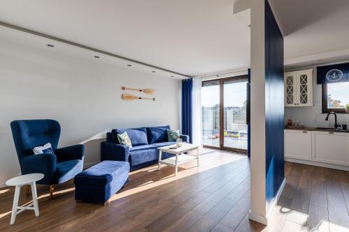 a living room with blue chairs and a kitchen at Amare Apartments B1 in Mosty