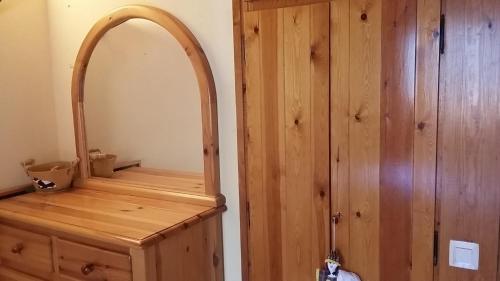 a bathroom with a mirror and a wooden cabinet at Apartamentos Tanau in Baqueira-Beret