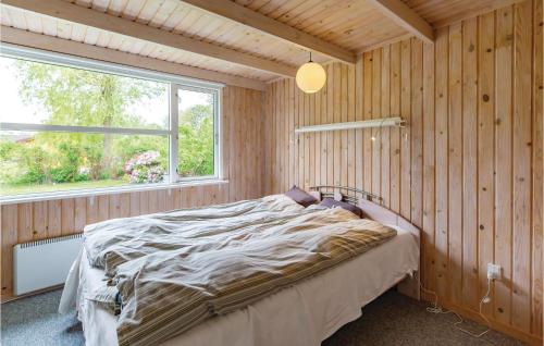 - une chambre avec un lit dans un mur en bois dans l'établissement 3 Bedroom Beautiful Home In Fllenslev, à Føllenslev