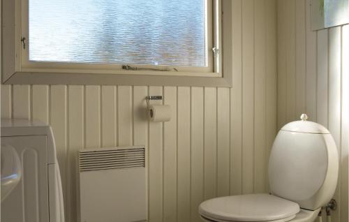 a bathroom with a white toilet and a window at Cozy Home In Rm With Kitchen in Bolilmark
