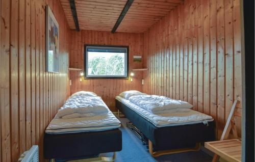 Duas camas num quarto com paredes de madeira e uma janela em Cozy Home In Rm With Kitchen em Bolilmark