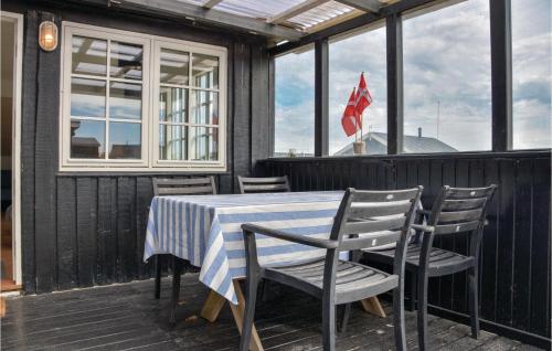 a table and chairs on a deck with windows at Three-Bedroom Holiday Home In Ulfborg in Fjand Gårde