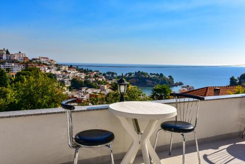 a table and chairs on a balcony with a view of the ocean at Apartments Hillside in Ulcinj