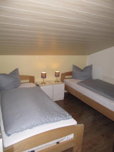 two beds in a room with two lamps on tables at Buchenweg 20a in Isenbüttel