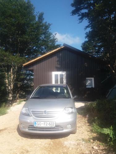 a car parked in front of a small building at Katun Ljeljenak in Pluzine