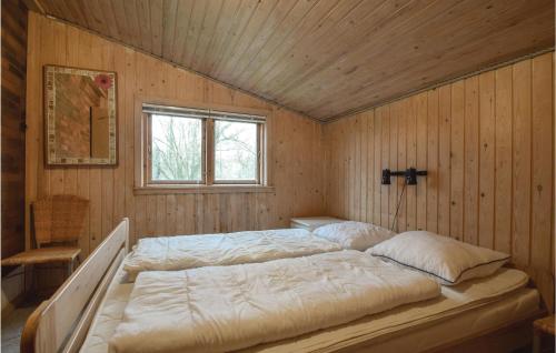 TranekærにあるAwesome Home In Tranekr With 4 Bedrooms, Sauna And Wifiの木製の壁にベッド2台が備わるベッドルーム1室