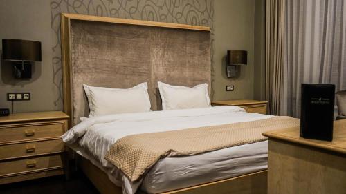 a bedroom with a large bed with a large headboard at JELSOMINOHotel in Astana