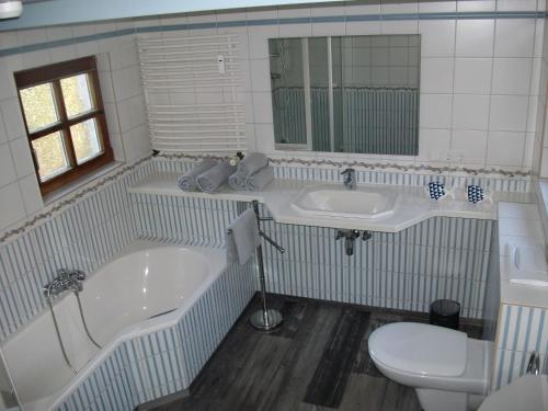 ein Badezimmer mit zwei Waschbecken, einem WC und einer Badewanne in der Unterkunft moij Stuuv in Greetsiel