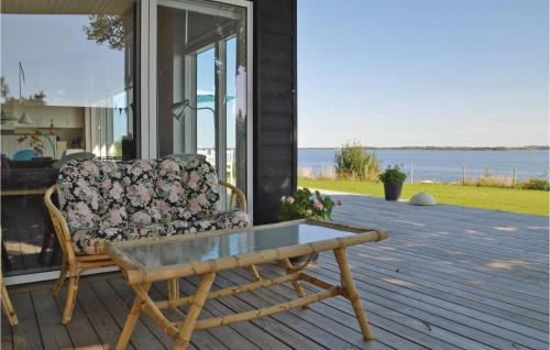 a couch sitting on a porch with a coffee table at Holiday Home Roslev With A Fireplace 01 in Øster Lyby