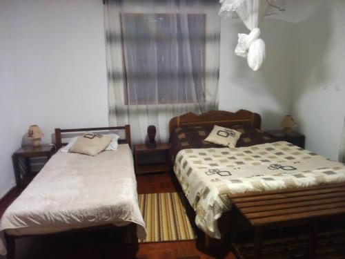 a bedroom with two beds and a window at Chambre d'hôtes Valiha in Ivato