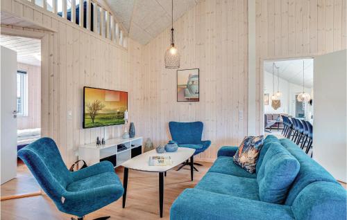 a living room with a blue couch and chairs at Lovely Home In Nørre Nebel With Wifi in Nørre Nebel