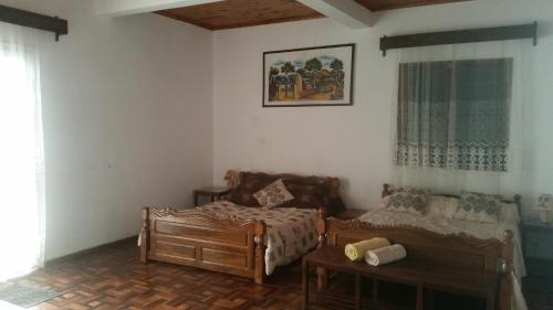 a bedroom with two beds and a table and a window at Chambre d'hôtes Valiha in Ivato