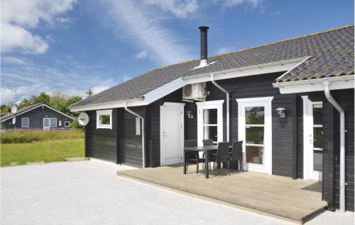 a black and white house with a wooden deck at Holiday Home Ildervej I in Hemmet