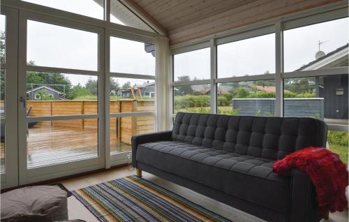 a living room with a couch in front of windows at Holiday Home Ildervej I in Hemmet