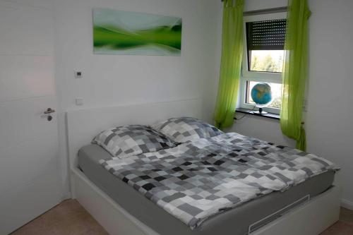 a bed in a bedroom with green curtains and a window at Design Apartment Harz-Relax in Harzgerode