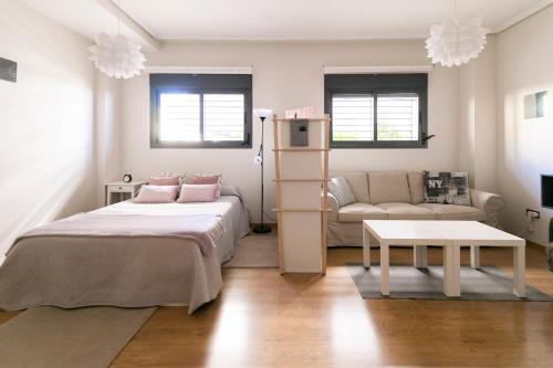 salon z łóżkiem i kanapą w obiekcie Apartamento Málaga Litoral Beach w Maladze