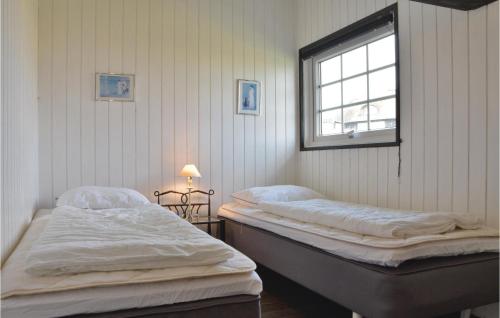 two twin beds in a room with a window at Stunning Home In Ringkbing With Kitchen in Søndervig