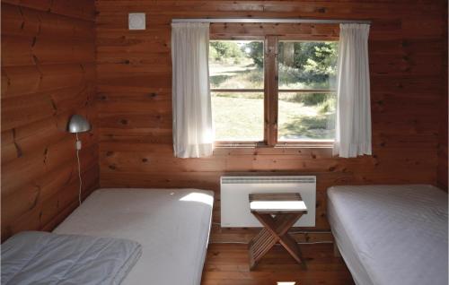 a bedroom with two beds and a window in a log cabin at 3 Bedroom Beautiful Home In lbk in Ålbæk