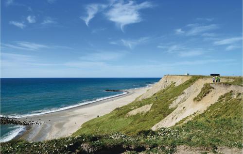 a beach with people standing on top of a cliff at Klitborgen in Harboør