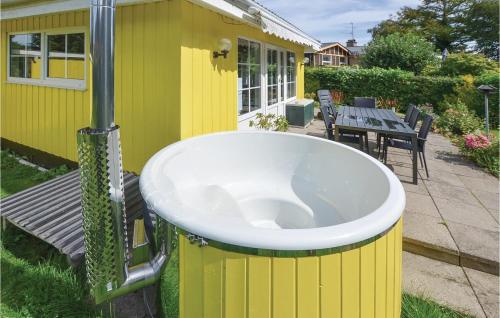 a yellow house with a toilet in the yard at Two-Bedroom Holiday Home In Broager in Broager