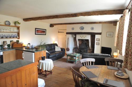 een woonkamer met een bank en een tafel bij Steppes Farm Cottages in Monmouth