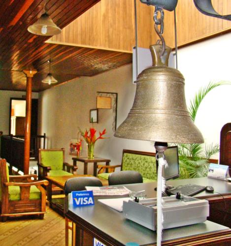 a large bell hanging from the ceiling in a living room at Hospedaje Casa Real in Salamina