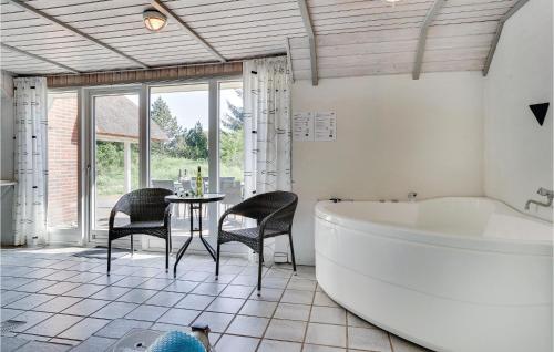 ブラーバンドにあるNice Home In Blvand With Sauna, Wifi And Private Swimming Poolのバスルーム(バスタブ、テーブル、椅子付)