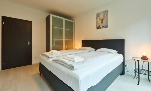 um quarto com uma cama grande e lençóis brancos em Residence Port Karolina em Praga