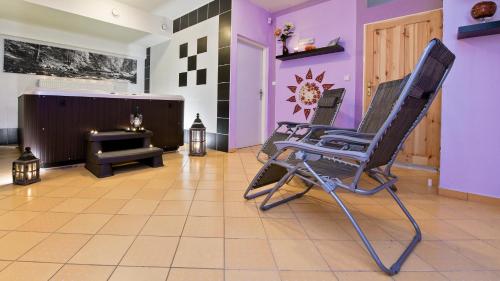 two rocking chairs in a room with purple walls at Wellness Penzion Eva in Dolní Moravice