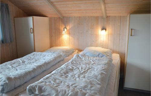 two beds in a room with wooden walls at 4 Bedroom Pet Friendly Home In Ringkbing in Halkær