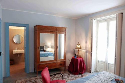 Habitación con dormitorio con cama y espejo. en Agrumè Country House, en Santa Venerina