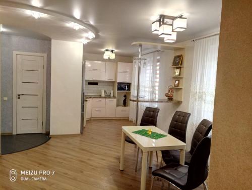 a kitchen and dining room with a table and chairs at Apartment on Zhaloytskaga 35 in Pinsk