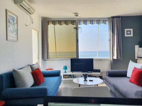a living room with two blue couches and a television at Sea View Nik Apartment in Durrës