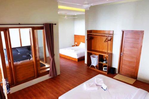 a large room with two beds and a room with at Gili One Resort in Gili Trawangan