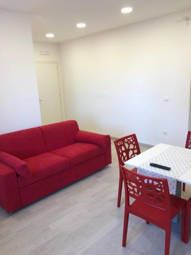 a living room with a red couch and a table at Attico Lady D in Paola