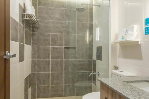 a bathroom with a shower with a toilet and a sink at Microtel Inn & Suites by Wyndham San Fernando in San Fernando