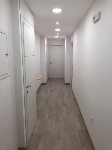 an empty hallway with white walls and wooden floors at Attico Lady D in Paola